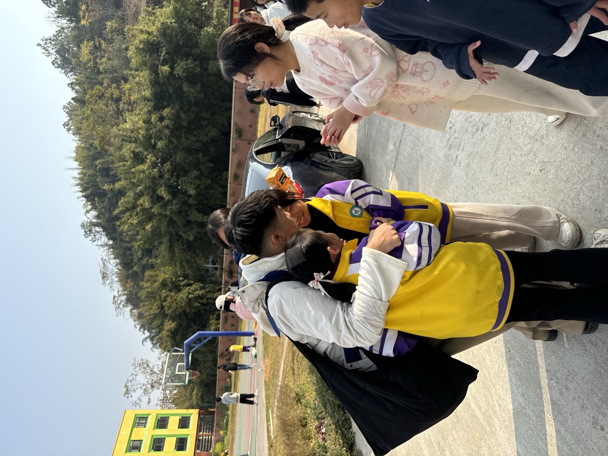 義工在球場上擁抱道別的孩子